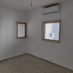 חדר עם מזגן מותקן על הקיר ותאורה פשוטה