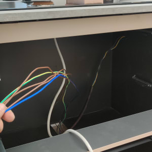 חוטי חשמל צבעוניים ביד בתוך ארון פתוח