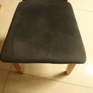 כיסא עם ריפוד בד כהה על מושב עץ