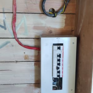 לוח חשמל עם חוטים צבעוניים על קיר עץ