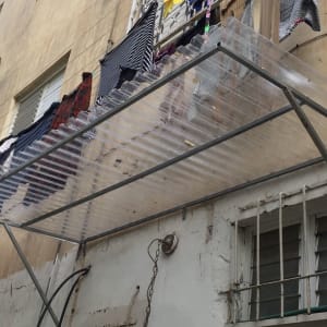 מסגרת מתכת עם כיסוי פלסטיק שקוף על קיר בניין