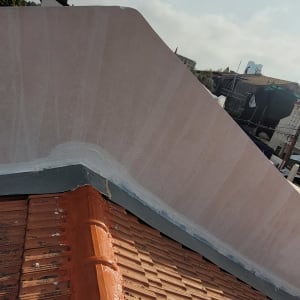 גג רעפים חום עם קיר תומך צבוע בלבן