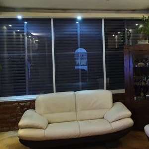 תריסי אלומיניום כהים בחלון גדול בסלון