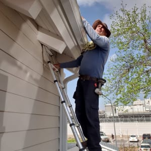 אדם על סולם מתקן גג עם מרזב