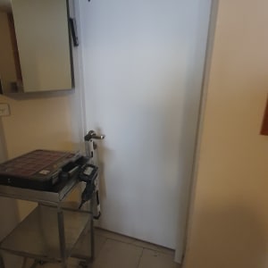 דלת לבנה עם ידית מתכת וכלי עבודה ליד