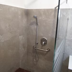 מקלחת עם ראש טוש, ידית אחיזה וספסל עץ