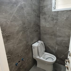 אסלה בחדר אמבטיה עם קירות אפורים