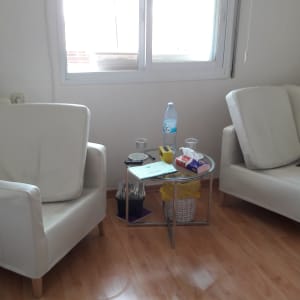 שני כורסאות לבנות ליד שולחן קטן עם חפצים