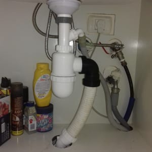 צנרת מתחת לכיור עם חיבורים ואביזרים