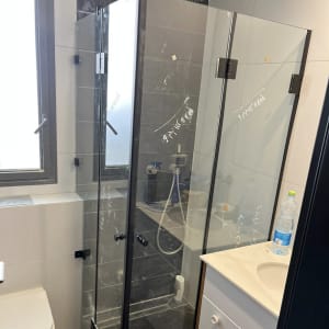 מקלחון זכוכית עם דלתות שקופות ומסגרת שחורה