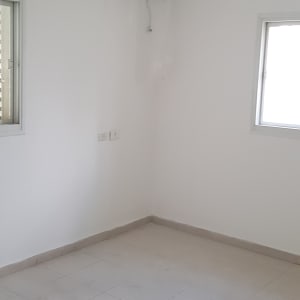 חדר עם קירות צבועים בלבן ומזגן מכוסה בניילון