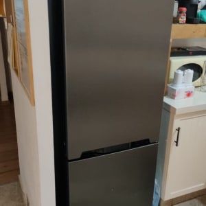 מקרר אפור עומד ליד קיר במטבח