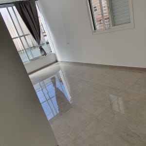 רצפה מבריקה בחדר ריק עם חלון ווילון