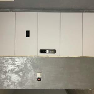 דלת לבנה עם ידית כסופה על קיר אפור