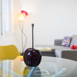 פסל דמוי דובדבן על שולחן זכוכית