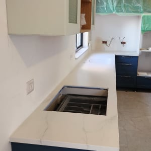 משטח שיש לבן עם כיור מובנה במטבח