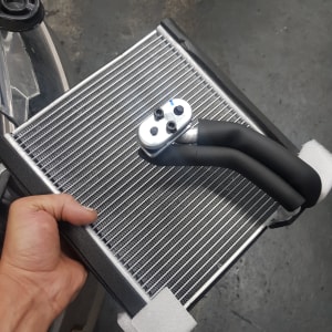 רדיאטור קטן עם צינורות שחורים ביד אדם