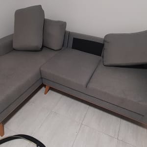 ספה אפורה עם כריות, כתמים על המושב