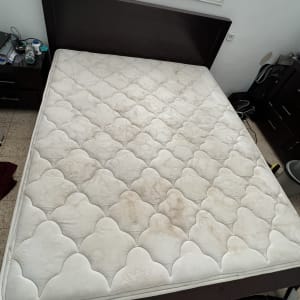 מזרן עם כתמים כהים על מיטה בחדר שינה