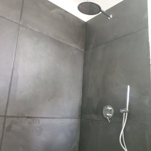 חיפוי קירות מקלחון באריחי גרניט פורצלן אפורים עם ראש גשם ומזלף