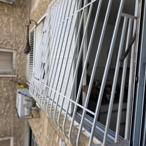 סורגי מתכת מותקנים על חלון בניין מגורים