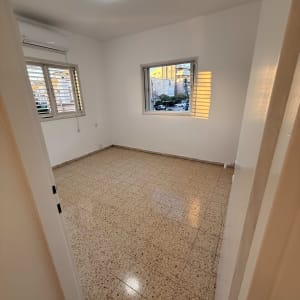 חדר ריק עם רצפה נקייה וחלונות פתוחים