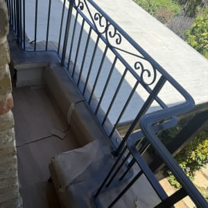 מעקה מרפסת צבוע עם ניירות הגנה על הרצפה