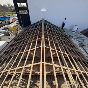 מבנה גג בעבודת בנייה עם אדם עומד בצד