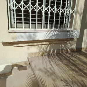 חלון עם סורגים מעל מדרגות אבן