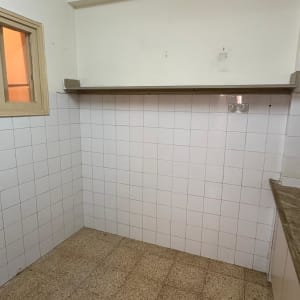 קיר עם אריחים לבנים ומדף עץ