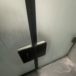 דלת זכוכית למקלחת עם ידית מתכת שחורה