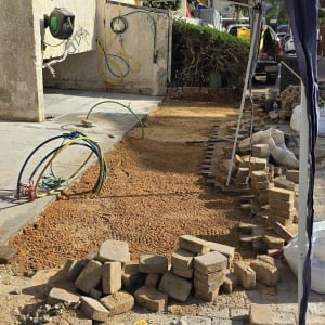 ערימת לבנים, צינורות וכלי עבודה באתר שיפוץ חיצוני