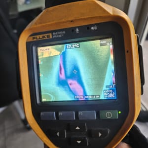 מד חום תרמי מציג תמונה צבעונית של אזור עם טמפרטורה.