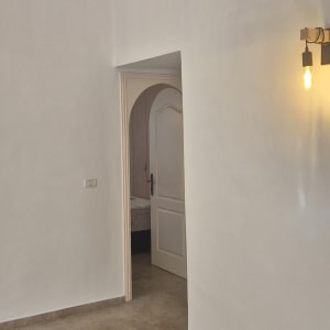 קיר צבוע בלבן עם מנורה דולקת