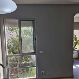 קיר צבוע באפור עם חלון זכוכית גדול