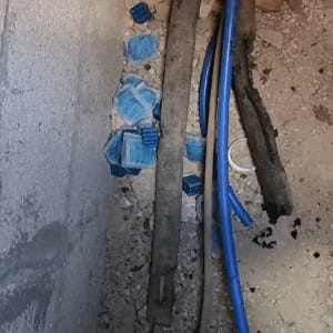 חבילות רעל עכברים כחולות על רצפה ליד צינורות