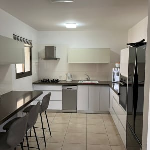 מטבח מודרני עם כיסאות בר, כיור ותנור