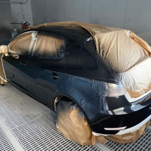 רכב מכוסה בניירות להגנה במהלך צביעת גוף הרכב