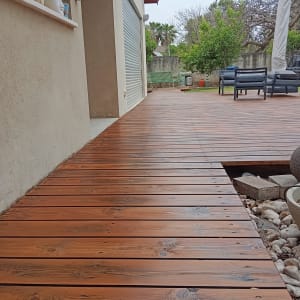 דק עץ חום ליד קיר חיצוני של בית