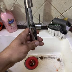 יד מחזיקה צינור ברז בכיור מטבח