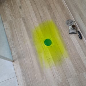 צינור ניקוז עם צבע זוהר על רצפת עץ