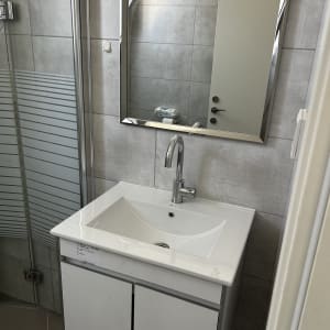 כיור אמבטיה עם מראה וברז בחדר רחצה