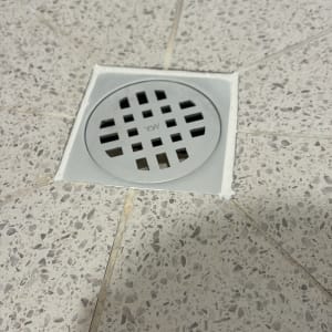 פתח ניקוז מרובע עם רשת מתכת ברצפה