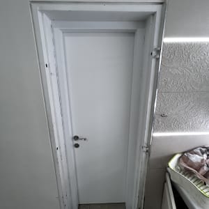 דלת לבנה עם ידית מתכת בחדר