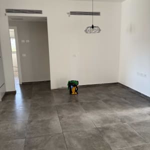 פח צבע על רצפה בחדר ריק עם קירות לבנים