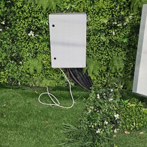 קופסת חשמל עם כבלים על רקע קיר ירוק