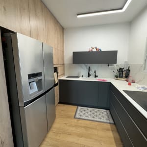 מטבח מודרני עם ארונות אפורים ודלתות עץ