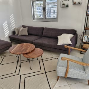 ספה סגולה עם כריות על שטיח בהיר