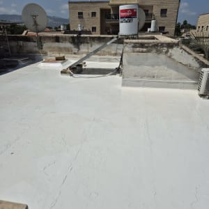 גג אטום בחומר לבן עם דוד שמש ואנטנה