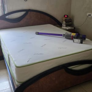 מיטה עם מזרן ושואב אבק בחדר שינה